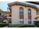 Exterior view of a well-maintained condo building with arched windows and lush landscaping at 2640 Enterprise E Rd # B25, Clearwater, FL 33759