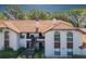 Charming condo with a red tile roof, stucco walls, and a inviting balcony, surrounded by lush green landscaping at 2640 Enterprise E Rd # B25, Clearwater, FL 33759
