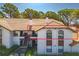 Charming condo with a red tile roof, stucco walls, and a inviting balcony, surrounded by lush green landscaping at 2640 Enterprise E Rd # B25, Clearwater, FL 33759