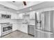 Bright kitchen featuring white cabinets, stainless steel appliances, and modern lighting at 2640 Enterprise E Rd # B25, Clearwater, FL 33759