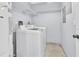 Clean laundry room with washer, dryer, storage shelves, and a water heater in a bright space at 2640 Enterprise E Rd # B25, Clearwater, FL 33759