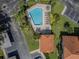 Aerial view of a community pool with lounge chairs and lush landscaping, near parking and buildings at 2640 Enterprise E Rd # B25, Clearwater, FL 33759