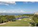 Scenic golf course view with lush green fairways and a serene pond under a bright blue sky at 2900 Cove Cay Dr # 7C, Clearwater, FL 33760