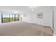 Bright, spacious living room featuring large windows and neutral carpet at 2900 Cove Cay Dr # 7C, Clearwater, FL 33760