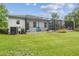 Expansive green backyard with a screened-in patio, offering peaceful views of the surrounding landscape at 32015 Summerglade Dr, Wesley Chapel, FL 33545