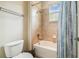 Cozy bathroom with a shower over tub, tiled surround, and a bright window offering natural light at 32015 Summerglade Dr, Wesley Chapel, FL 33545