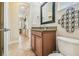 Bathroom featuring a wood vanity, dark framed mirror, and a doorway leading to other rooms at 32015 Summerglade Dr, Wesley Chapel, FL 33545