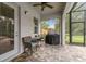 Relaxing patio with a grill, small table, and chairs overlooking the backyard and outdoor area at 32015 Summerglade Dr, Wesley Chapel, FL 33545