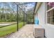 Extended screened-in patio with brick pavers providing views of the grassy yard and surrounding nature at 32015 Summerglade Dr, Wesley Chapel, FL 33545