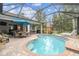 Inviting screened-in pool with brick-paved patio, multiple seating areas, umbrella, and views of the landscaped backyard at 32015 Summerglade Dr, Wesley Chapel, FL 33545
