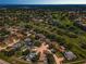 Expansive aerial view showcasing a residential community nestled around a lush green golf course and shimmering water features at 3242 Brushwood Ct, Clearwater, FL 33761