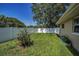 Well-maintained backyard with a green lawn, privacy fence, and garden beds at 3242 Brushwood Ct, Clearwater, FL 33761