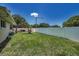 Spacious backyard featuring a well-maintained lawn, white fence, and a covered patio area at 3242 Brushwood Ct, Clearwater, FL 33761