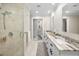 Bright bathroom featuring a walk-in shower with glass door, double vanity, and modern fixtures at 3242 Brushwood Ct, Clearwater, FL 33761