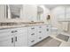 Bathroom featuring double vanity with marble counters, white cabinets, and modern fixtures at 3242 Brushwood Ct, Clearwater, FL 33761
