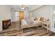 Bright bedroom featuring wood-look floors, ceiling fan, shuttered windows, and sliding barn door to bathroom at 3242 Brushwood Ct, Clearwater, FL 33761
