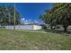 Exterior shot of the home with a manicured lawn, mature trees, and a secure white fence at 3242 Brushwood Ct, Clearwater, FL 33761