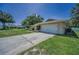 A suburban home featuring an attached garage, green lawn, and manicured landscaping in a tranquil setting at 3242 Brushwood Ct, Clearwater, FL 33761