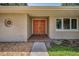 Inviting front entrance featuring unique door and an eye-catching sun and moon themed wall decor at 3242 Brushwood Ct, Clearwater, FL 33761