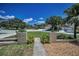 Inviting front yard featuring decorative stone columns, lush landscaping, and a well-maintained lawn at 3242 Brushwood Ct, Clearwater, FL 33761