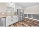 Modern kitchen includes a stainless steel refrigerator, white cabinets, and wood-look floors at 3242 Brushwood Ct, Clearwater, FL 33761