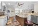 Open kitchen area with a center island, seating, stainless appliances, and wood-look floors at 3242 Brushwood Ct, Clearwater, FL 33761