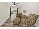 Cozy living room with wood floors, ceiling fan, and sliding glass doors to outdoor patio area at 3242 Brushwood Ct, Clearwater, FL 33761