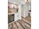 Basement wet bar area with beverage cooler, shelving, white cabinets, and wood-look flooring at 3242 Brushwood Ct, Clearwater, FL 33761