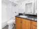 Bathroom with granite countertop, wood cabinets and shower-tub combo at 3300 Haviland Ct # 103, Palm Harbor, FL 34684