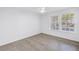 Well-lit bedroom showcasing wood-look floors, bright windows, and a ceiling fan at 3305 Haviland Ct # 101, Palm Harbor, FL 34684