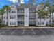 Three-story condo building with palm trees and ample parking at 3305 Haviland Ct # 101, Palm Harbor, FL 34684