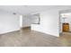 Spacious living area with wood-look floors, featuring an open layout with a view into the kitchen at 3305 Haviland Ct # 101, Palm Harbor, FL 34684