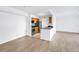 Open-concept living room with modern wood floors flowing into the kitchen at 3305 Haviland Ct # 101, Palm Harbor, FL 34684