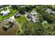 Aerial view of a grand estate featuring a pool, solar panels, lush lawns, and a private lake with dock at 3425 W Forest Lake Cir, Sarasota, FL 34232