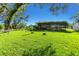 Sprawling green backyard featuring a vine-covered structure, perfect for outdoor activities and relaxation at 3425 W Forest Lake Cir, Sarasota, FL 34232