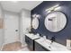 This bathroom features dual sinks, modern lighting, and a dark blue accent wall at 3425 W Forest Lake Cir, Sarasota, FL 34232