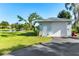 Detached garage with an overhead door, situated on a well-maintained lawn with water access at 3425 W Forest Lake Cir, Sarasota, FL 34232