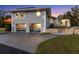 Exterior view of home featuring a modern, glass two-car garage and stone facade at 3425 W Forest Lake Cir, Sarasota, FL 34232