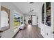 Bright hallway with hardwood floors, large windows with backyard view, and a decorative mirror at 3425 W Forest Lake Cir, Sarasota, FL 34232