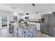 Bright, open kitchen with stainless steel appliances, white cabinets, and a large center island with marble countertop at 3425 W Forest Lake Cir, Sarasota, FL 34232