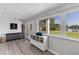Bright living room with wood floors and a view of the lake from a large window at 3425 W Forest Lake Cir, Sarasota, FL 34232