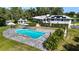 Aerial view of a private pool, gazebo, and lush greenery creating a serene backyard oasis with solar panels on the home at 3425 W Forest Lake Cir, Sarasota, FL 34232
