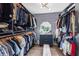 This walk-in closet features custom shelves, a mirrored dresser, a light fixture, and wallpaper accent wall at 3425 W Forest Lake Cir, Sarasota, FL 34232