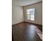An empty bedroom features a neutral color palette and modern wood-look flooring at 3536 Countrybrook Ln # 13, Palm Harbor, FL 34684