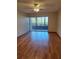 Bright bedroom with hardwood floors and a large window overlooking a patio at 3536 Countrybrook Ln # 13, Palm Harbor, FL 34684