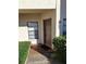 Inviting condo front door with tan exterior, decorative landscaping, and visible unit number at 3536 Countrybrook Ln # 13, Palm Harbor, FL 34684