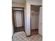 Hallway with neutral tile flooring leading to multiple closets with doors and wood trim at 3536 Countrybrook Ln # 13, Palm Harbor, FL 34684