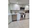 Bright kitchen features stainless steel appliances, white cabinetry, and stylish backsplash at 3536 Countrybrook Ln # 13, Palm Harbor, FL 34684