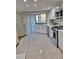 Well-lit kitchen boasting stainless steel appliances, white cabinets, and view of outdoor space at 3536 Countrybrook Ln # 13, Palm Harbor, FL 34684