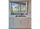 Bright and modern kitchen sink with stainless steel appliances, white cabinets, and natural light at 3536 Countrybrook Ln # 13, Palm Harbor, FL 34684